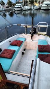 um barco com almofadas vermelhas numa doca na água em Bateau Voilier « Brenus lll » em Gruissan