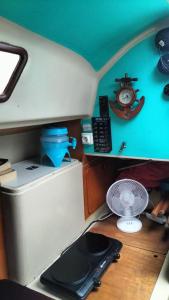 une cuisine miniature avec un ventilateur et un réveil sur une table dans l'établissement Bateau Voilier « Brenus lll », à Gruissan