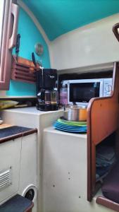 uma cozinha com uma mesa com placas e um micro-ondas em Bateau Voilier « Brenus lll » em Gruissan