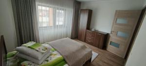 a small bedroom with a bed and a window at Apartament 2 camere in Râmnicu Vâlcea