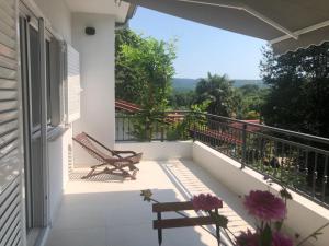 a balcony of a house with a bench and a view at Apartment Lena in Čižići