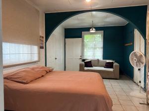 a bedroom with a bed and a couch and a window at CASA STELLA in Heredia