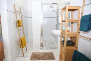 W łazience znajduje się prysznic i umywalka. w obiekcie L Orchidée Bleue, bas de villa, vue mer, piscine privée w mieście Sainte-Anne