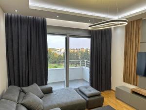 a living room with a couch and a large window at Enigma Apartment in Ulcinj