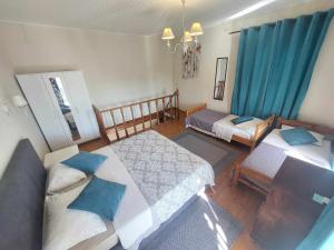 a bedroom with two beds and blue curtains at Alegria House 150m from the beach in Gouvia