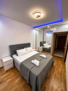 a bedroom with a large bed with two towels on it at Enigma Apartment in Ulcinj