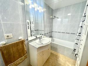 a bathroom with a sink and a mirror and a tub at Apartamento al lado de la playa in Moncófar