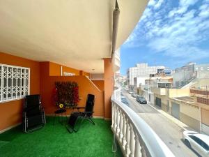 balcón con suelo verde y vistas a la calle en Apartamento al lado de la playa, en Moncófar