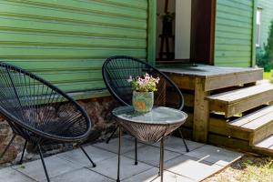two chairs and a table with a vase of flowers on a porch at Supeluse kodu in Pärnu