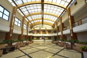 an empty lobby with chairs and a large ceiling at Hotel Royal Highness in Tinsukia