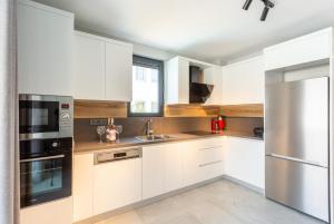 cocina con armarios blancos y nevera de acero inoxidable en Villa Exclusive Paradise 3, en Dalyan