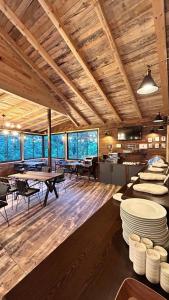 Kaledome Orman evleri في جامليهمشين: غرفة كبيرة مع طاولات وكراسي في مبنى