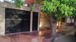 a garage with a tree in front of a building at Solaire Apart in Ciudad Lujan de Cuyo