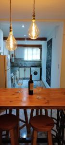 a kitchen with a wooden table with two wine glasses at Solaire Apart in Ciudad Lujan de Cuyo