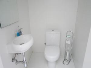 a white bathroom with a toilet and a sink at Townhouse Twenty in Żebbuġ