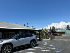 Un todoterreno blanco estacionado en un estacionamiento en Western Village Inn, en Willits