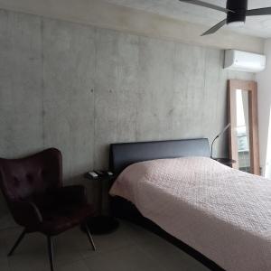 1 dormitorio con 1 cama y 1 silla en Ifreses Apartamento 11, en San José