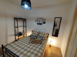 a bedroom with a bed with a checkered blanket at chambre proche de stade de france in Pierrefitte-sur-Seine +9 photos
