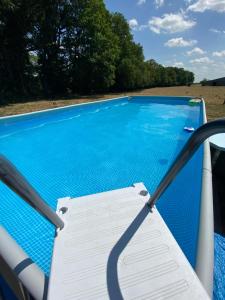 a blue swimming pool with a sign on a chair at L Orée Du Bois in Moncheux