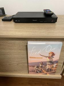 a book sitting on a desk next to a dvd player at Guest House Numazu Port - Vacation STAY 70099v in Numazu