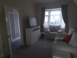 a living room with a couch and a tv at John Street in Shildon