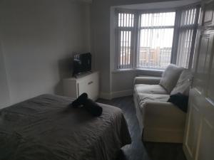 a bedroom with a bed and a couch and a tv at John Street in Shildon +4 photos