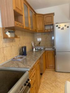 una cucina con frigorifero bianco e armadietti in legno di Duraku Apartment a Ulcinj