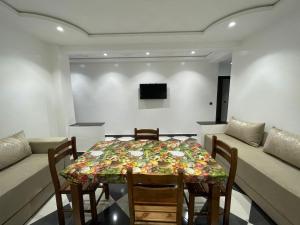 uma sala de jantar com uma mesa e cadeiras e um sofá em Hiba & Dina Apartments em Fnideq