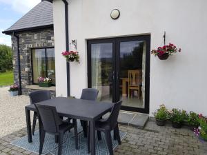 einen schwarzen Tisch und Stühle vor einem Haus in der Unterkunft Atlantic Coast Holiday Home in Mountcharles