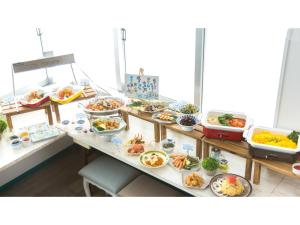 Hotel AreaOne Sakaiminato Marina - Vacation STAY 81682v في ساكايميناتو: بوفيه مع العديد من أطباق الطعام على طاولة
