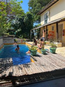 un groupe de personnes jouant dans une piscine dans l'établissement Vila Pepouze Hostel, à Morro de São Paulo