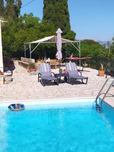 Vóvikes的住宿－Villa Serenity，一个带两把椅子和一张桌子的游泳池以及一把遮阳伞