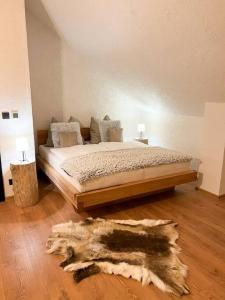 a bedroom with a large bed and a rug at Chalet Black Deer in Mýto pod Ďumbierom