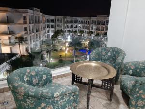 Zimmer mit 2 Stühlen, einem Tisch und einem großen Fenster in der Unterkunft COSTA BEACH Lux Family Apartment with Pools in Bouznika