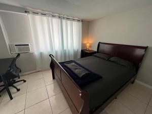 1 dormitorio con cama, escritorio y ventana en Oak Ridge House, en Tampa