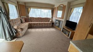 a living room with a couch and a television at Holiday Freedom in Clacton-on-Sea