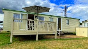 a house with a deck with an umbrella at Holiday Freedom in Clacton-on-Sea