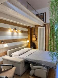 a bedroom with a bed and a chair and a guitar at La casa dei sogni in Falconara Marittima