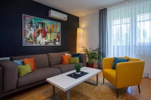 a living room with a couch and two chairs at Apartment Sladic in Sisak
