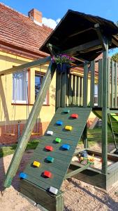 a wooden play structure with a slide in a house at NAD JEZIOREM - Apartamenty in Brenno