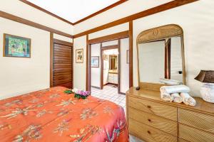 a bedroom with a bed and a mirror and a dresser at Kiahuna Plantation in Koloa