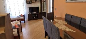 a living room with a table and chairs and a television at Vila Horizont Ksamil in Sarandë