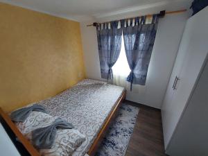 Etno House Jakic في باغينا باستا: غرفة نوم صغيرة بها سرير ونافذة