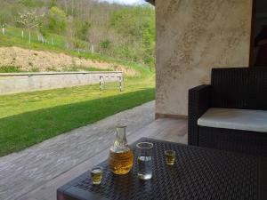 a table with a bottle of beer and glasses on it at Etno House Jakic in Bajina Bašta
