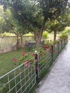 einen Zaun mit Blumen und einem Baum im Hof in der Unterkunft Kristina Mitllari 1 in Pogradec