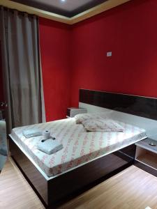 1 dormitorio con 1 cama con pared roja en Hotel Santos, en Santos