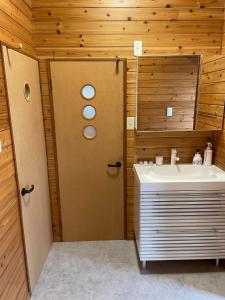 a bathroom with a white sink and a door at AYAMARUDO-MU - Vacation STAY 32625v in Amami