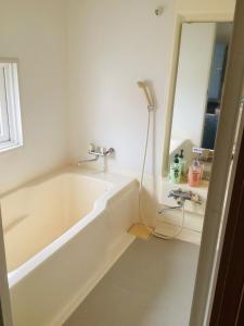 a bathroom with a bath tub and a mirror at Kamome Building 3F - Vacation STAY 54301v in Otaru