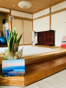 小樽市にあるKamome Building 3F - Vacation STAY 50177vの木製ベッド1台(植物付)が備わるベッドルームです。