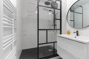 La salle de bains est pourvue d'une douche, d'un lavabo et d'un miroir. dans l'établissement Les 70's Dutreix, à Limoges